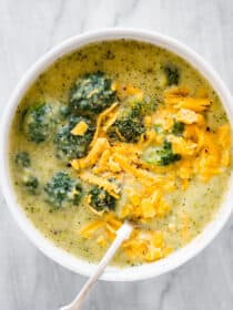 A white bowl filled with broccoli cheddar soup.