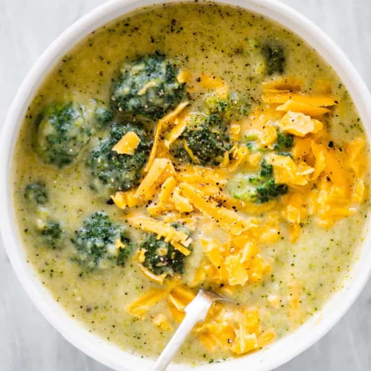 A white bowl filled with broccoli cheddar soup.