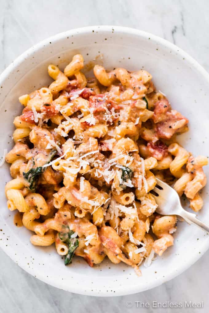 A bowl of Creamy Tomato Pasta with a fork inside.