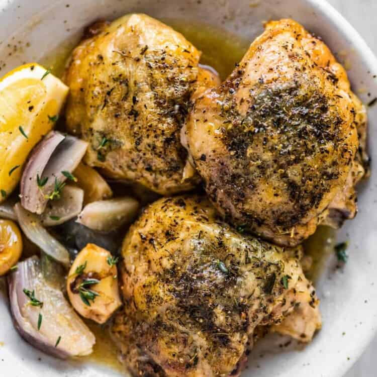 Herbs de Provence Chicken on a plate wit shallots and garlic.