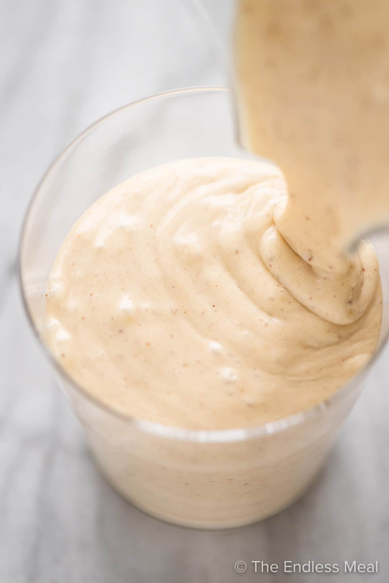 Peanut Butter Banana Smoothie being poured into a cup.
