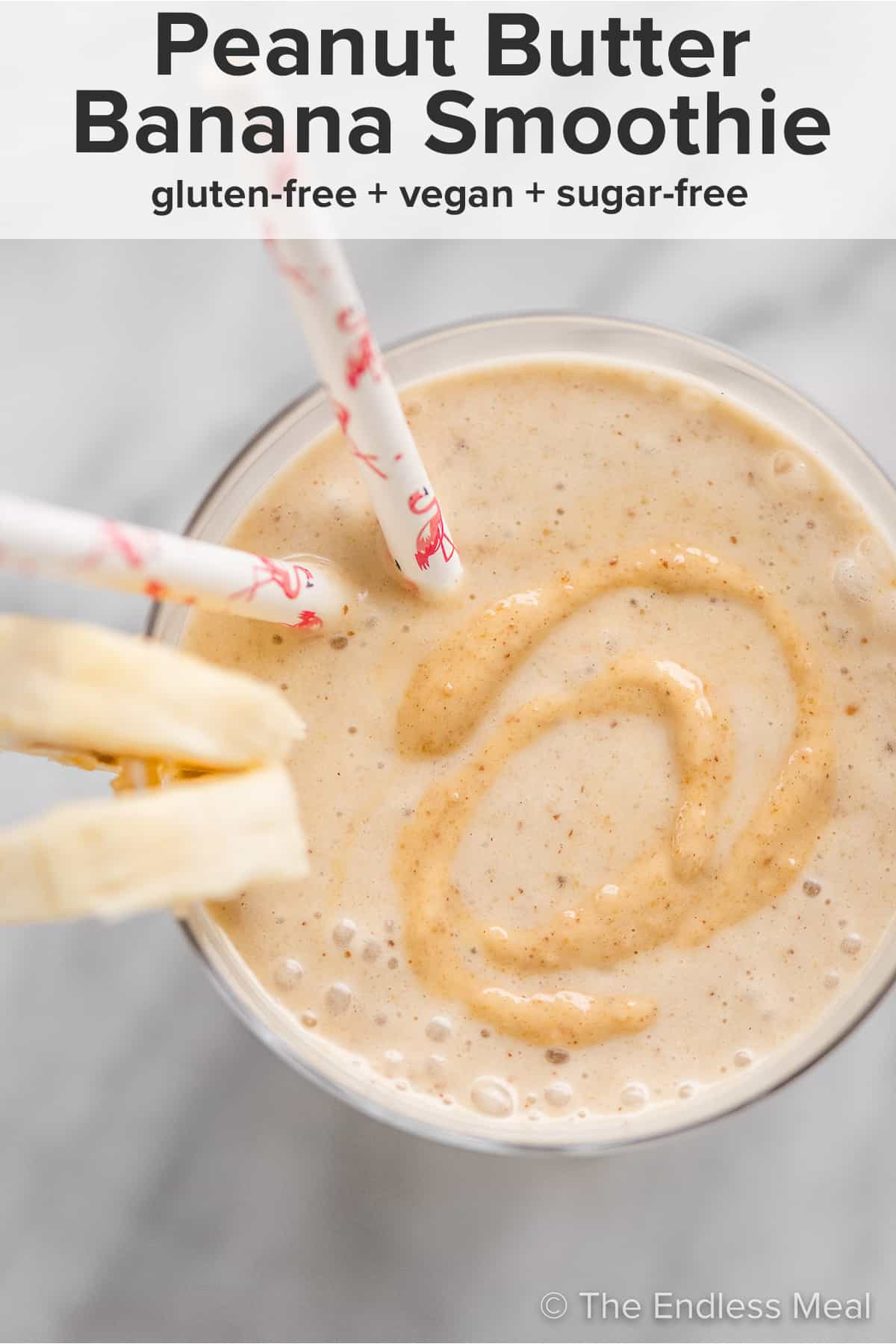 Looking down on a cup of Peanut Butter Banana Smoothie with banana slices on the side and the recipe title on top of the picture.