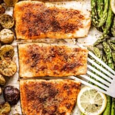 Sheet pan salmon on a baking sheet with potatoes and asparagus.