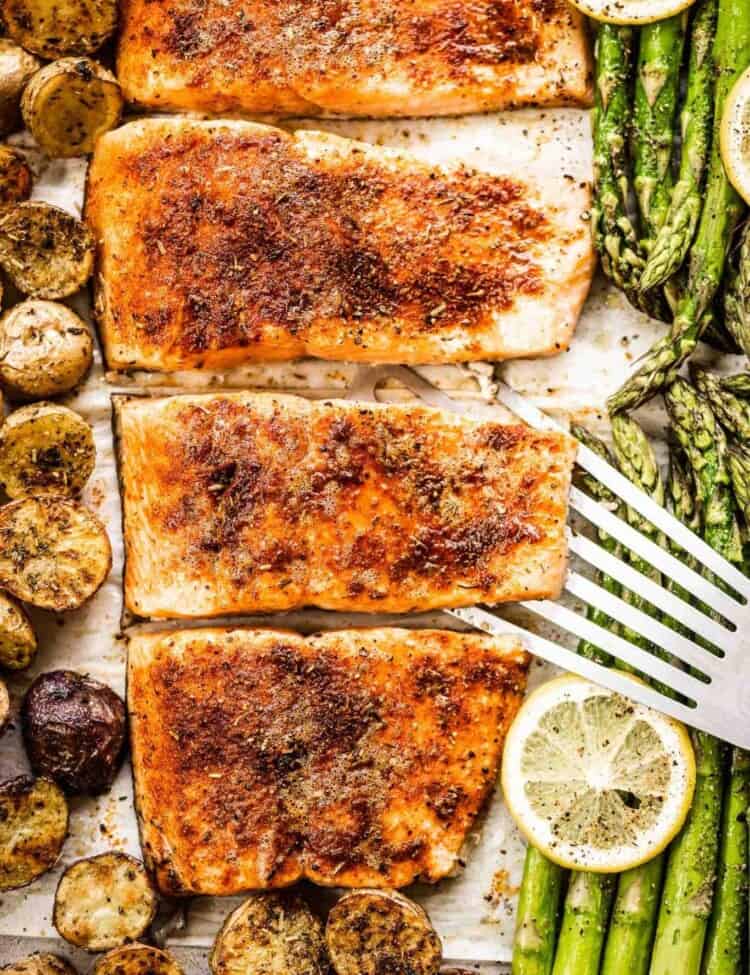 Sheet pan salmon on a baking sheet with potatoes and asparagus.