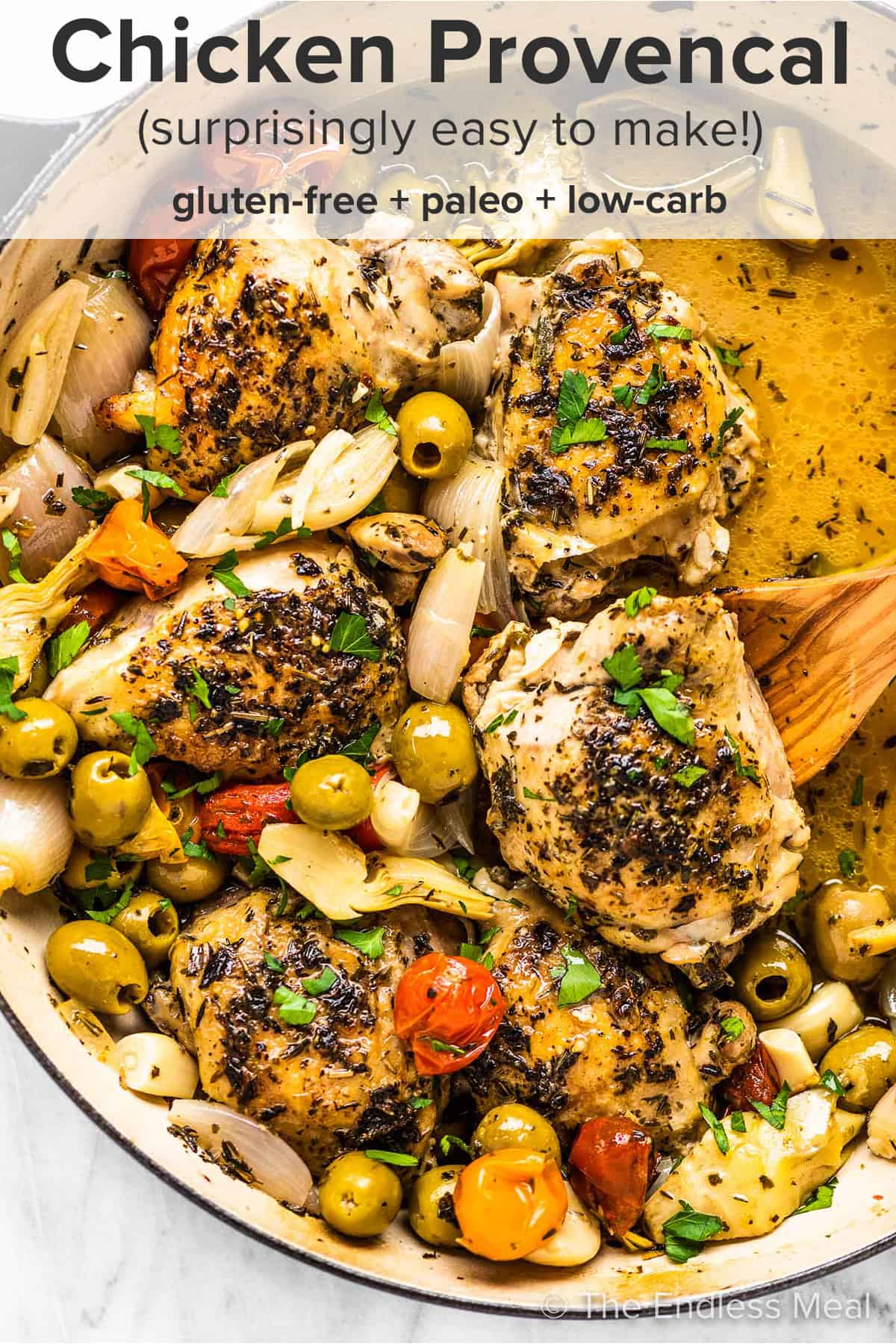 Chicken provencal in a braising pan with a wooden spoon and the recipe title on top of the picture.