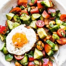 Healthy Breakfast Salad in a white bowl with a fried egg on top.