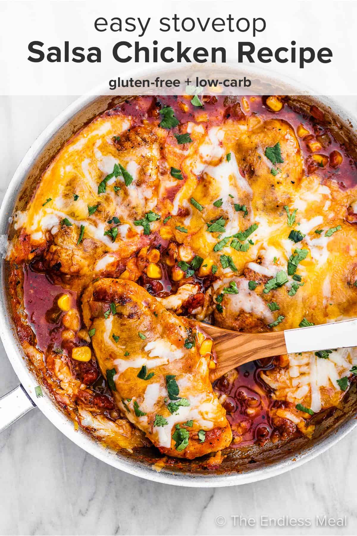 Cheesy salsa chicken in a pan with a wooden spoon with the recipe title on top of the picture.