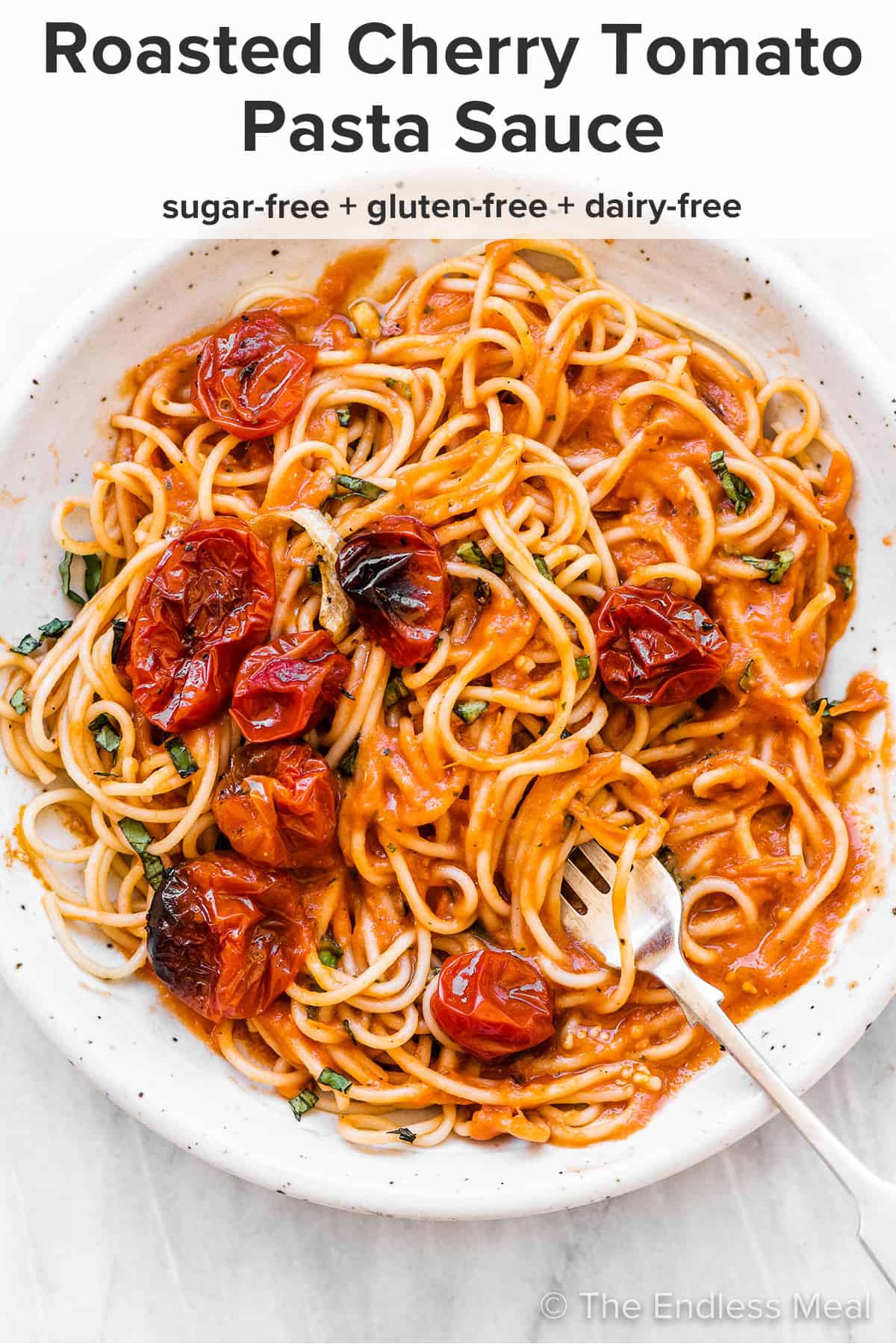 Roasted cherry tomato pasta sauce on spaghetti on a white plate and the recipe title on top of the picture.