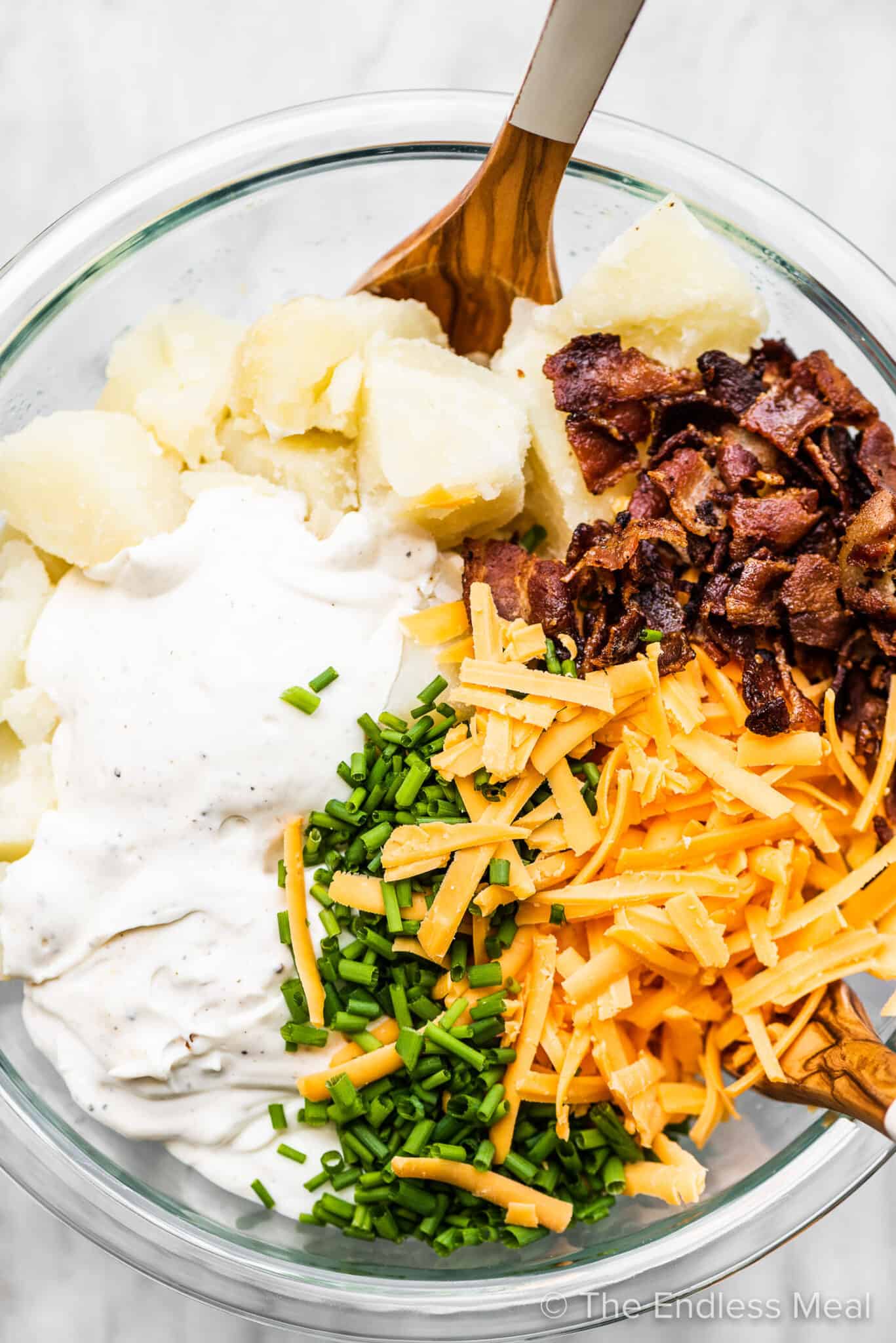 All the ingredients to make this baked potato salad recipe in a mixing bowl.