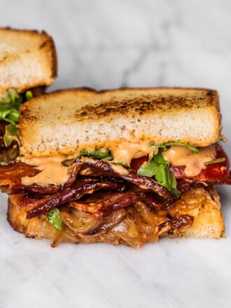 A bacon sandwich with lots of caramelized onions.