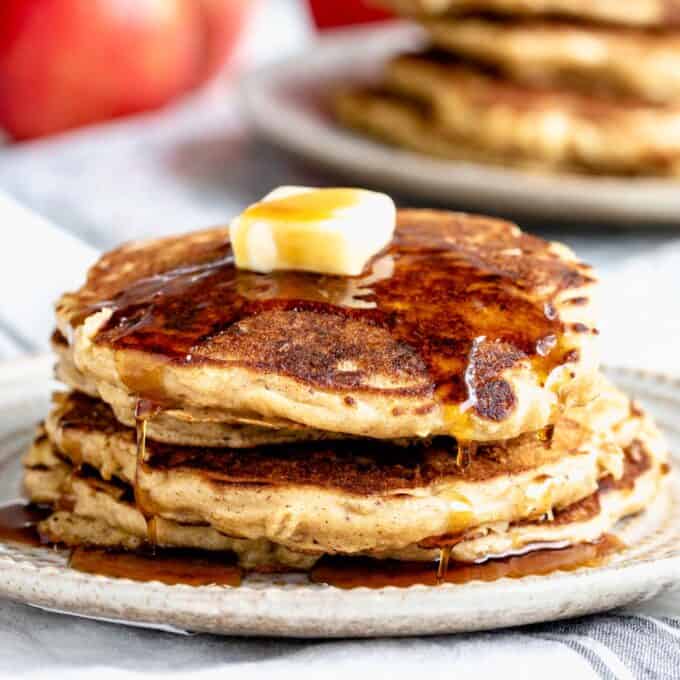 a stack of apple pancakes with butter and maple syrup on top