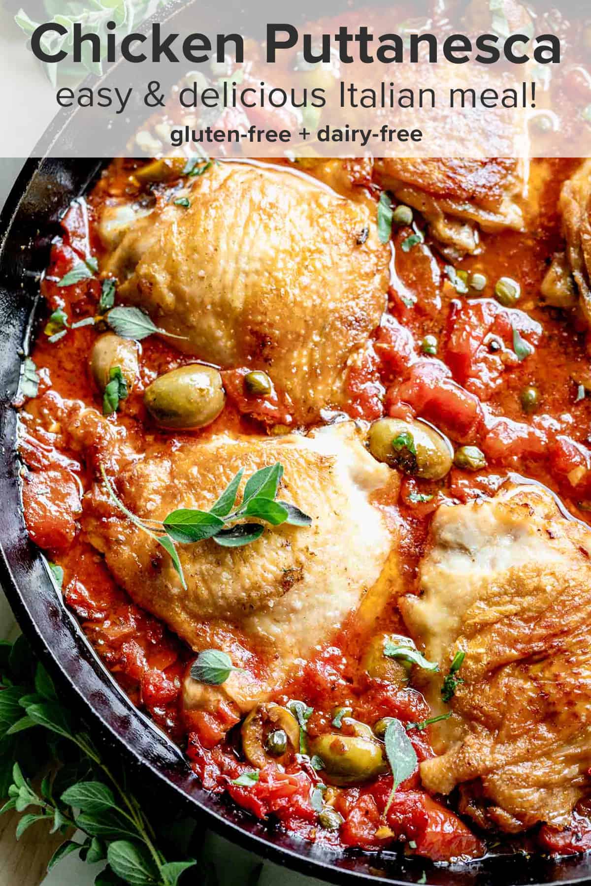close up of a skillet of chicken puttanesca with tomato sauce, olives, capers and crispy chicken thighs and the recipe title on top of the picture.