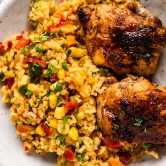 Spicy Mexican Rice on a plate with grilled chicken.