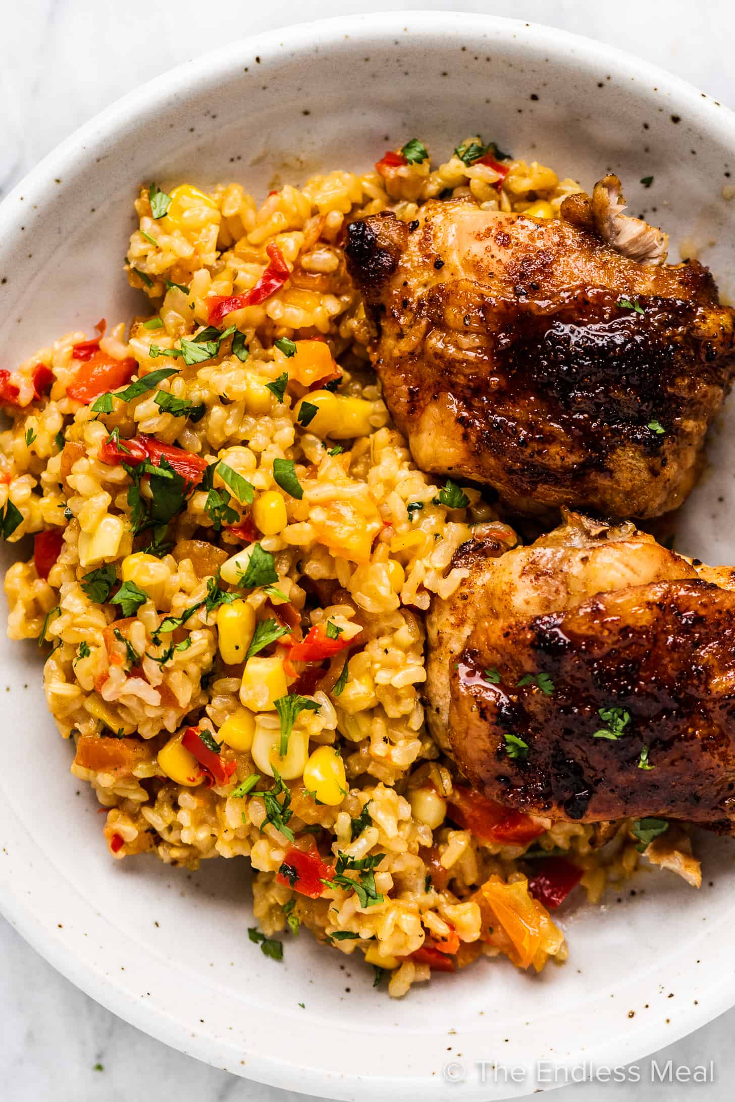 Spicy Mexican Rice on a plate with grilled chicken.