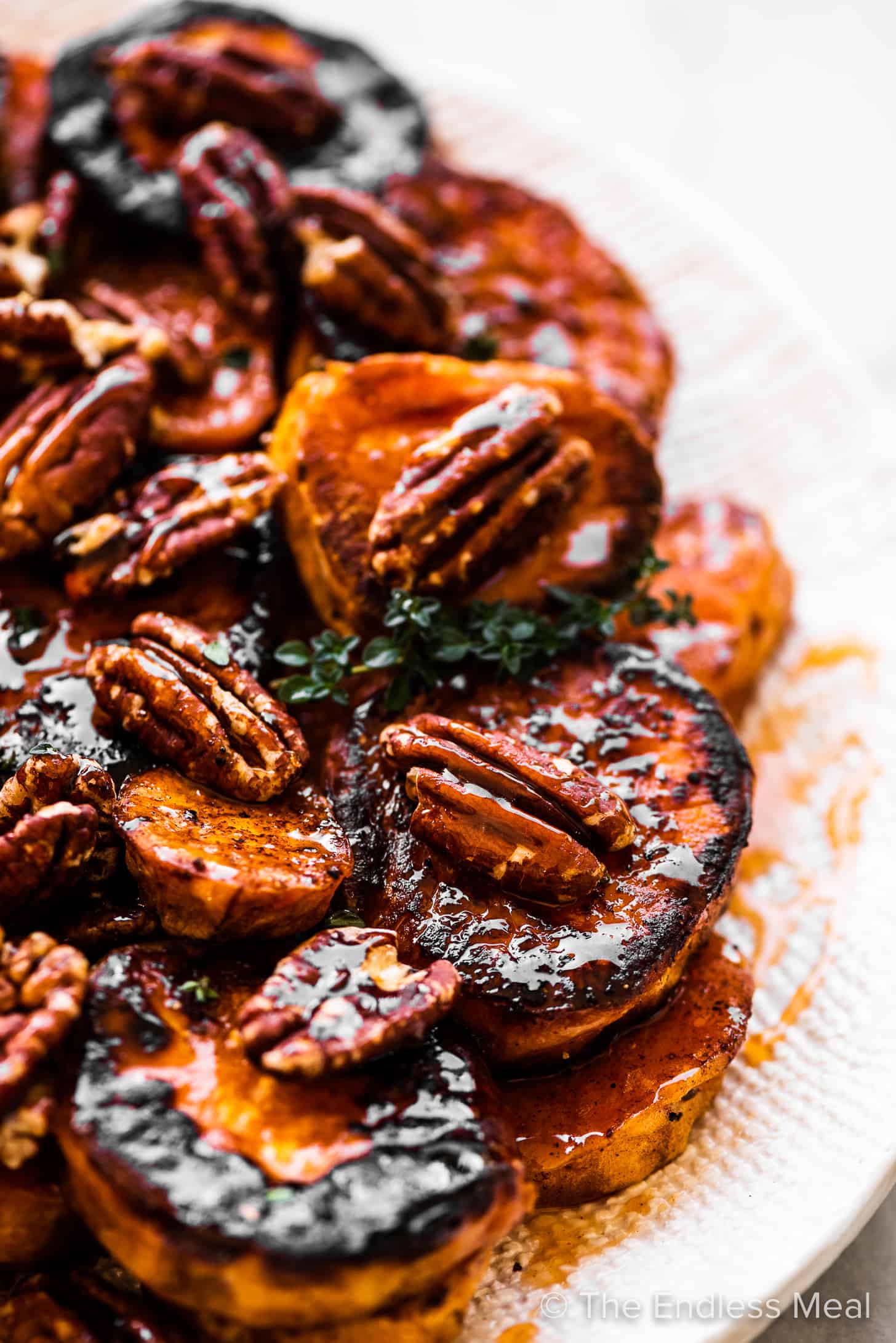 A close up of sweet potatoes and pecans smothered in hot honey.