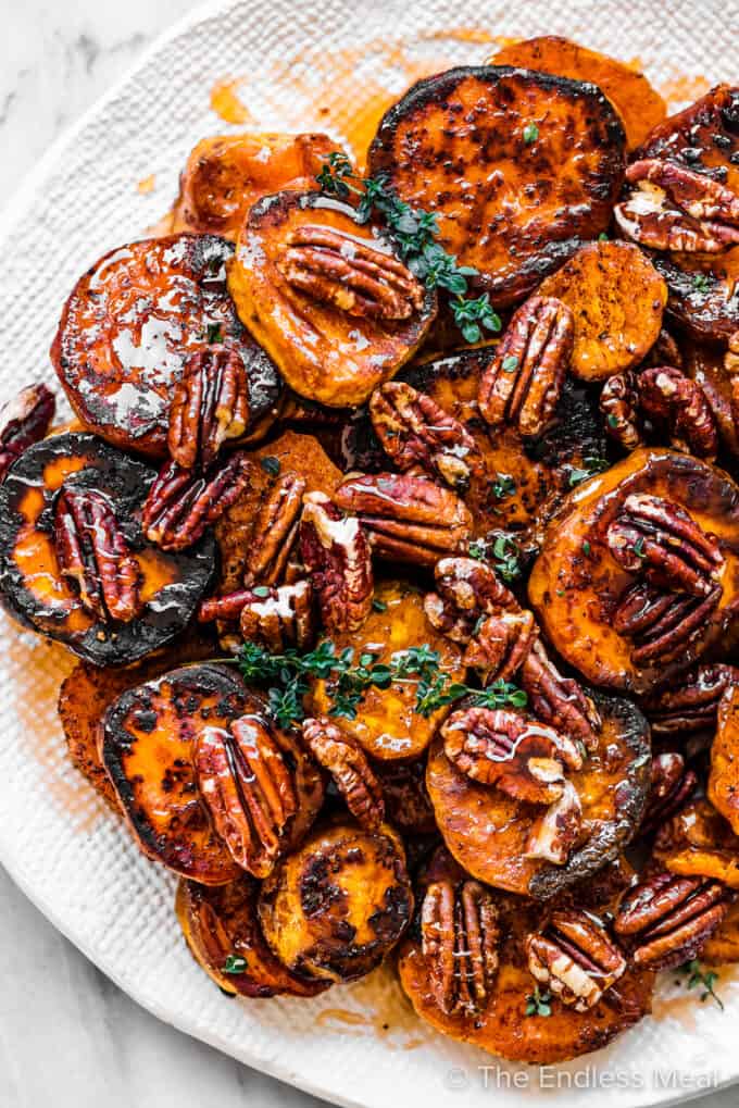 Hot honey roasted sweet potatoes and pecans on a serving plate.