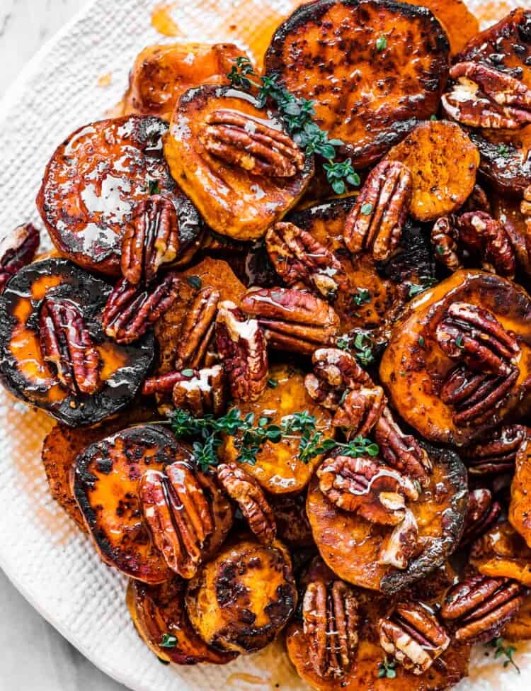 Hot honey roasted sweet potatoes and pecans on a serving plate.