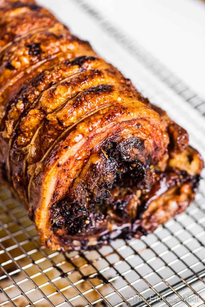 Looking at the side of porchetta on a cooling rack.