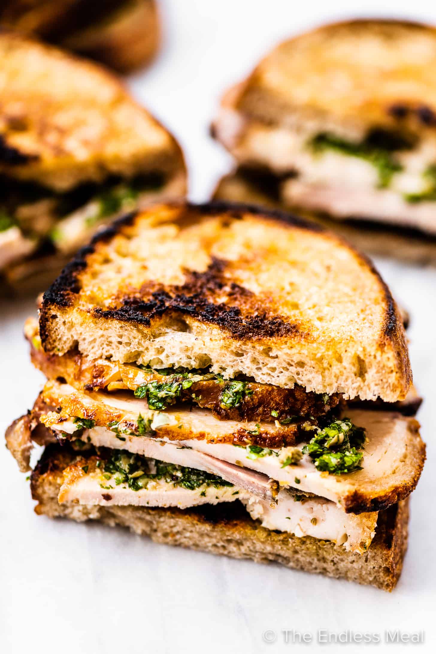 looking at the side of a porchetta sandwich with salsa verde.