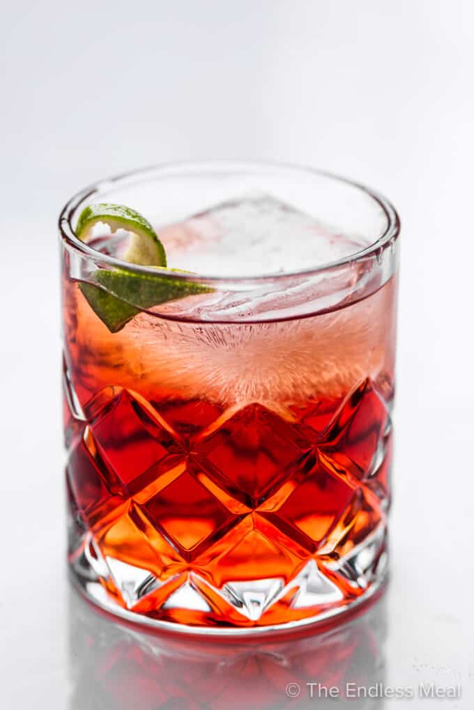 A rocks glass filled with a Tequila Negroni.