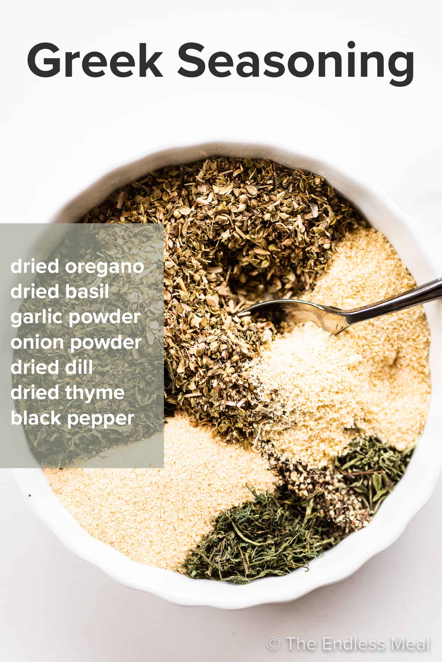 The spices in this Greek Seasoning Blend recipe in a mixing bowl with the recipe written on top of the picture. 