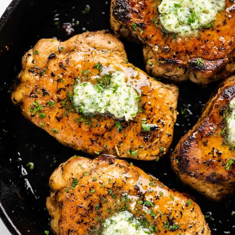 Pan Fried Pork Chops with honey garlic herb butter on top.