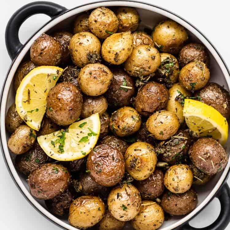 Roasted mini potatoes in a serving dish with lemon