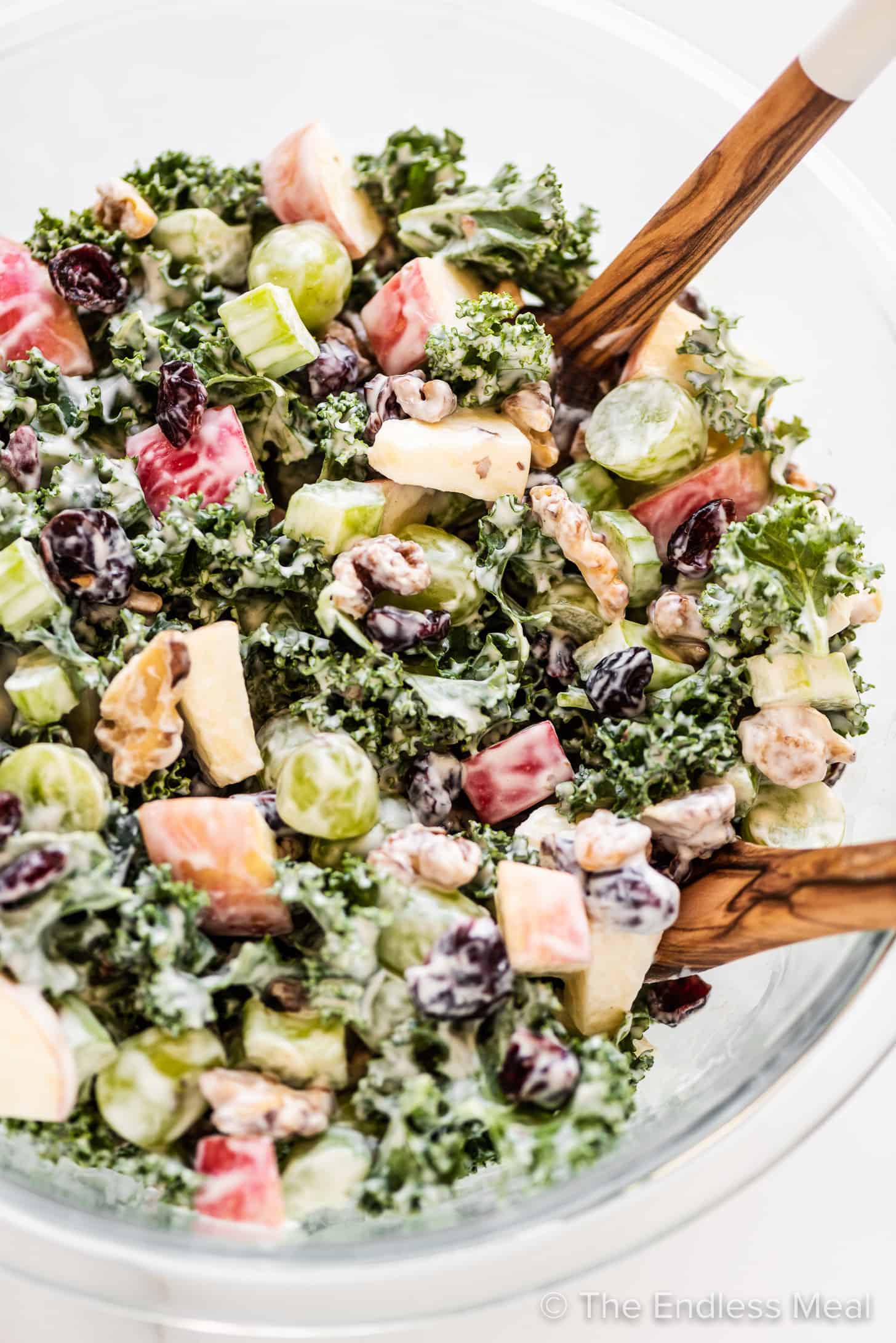 Kale Waldorf Salad with wooden salad tongs