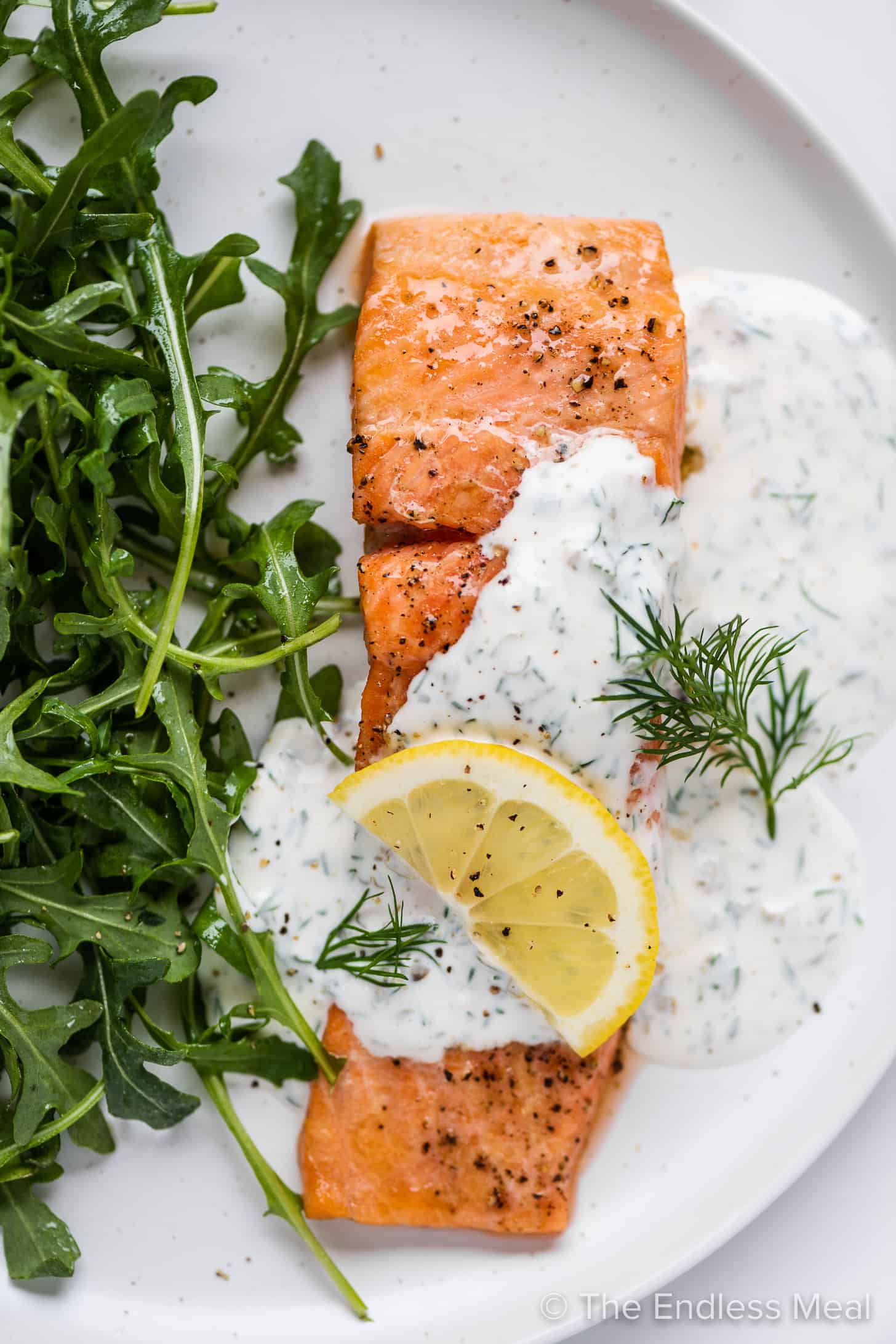 juicy salmon with lemon dill sauce on a plate. 