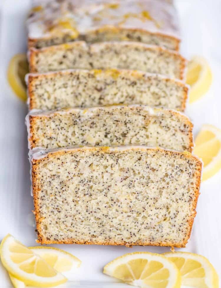 slices of lemon poppy seed banana bread with glaze on a serving platter