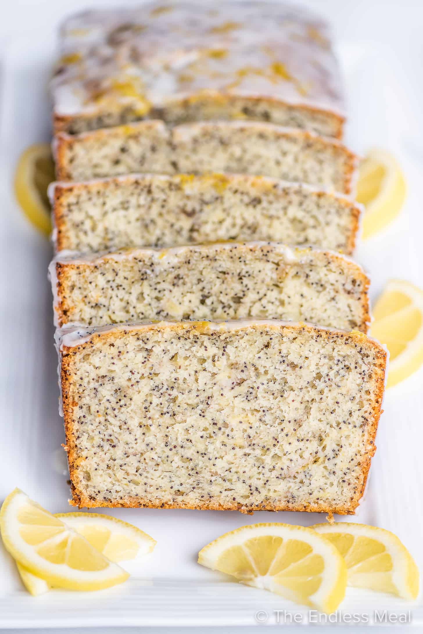 slices of lemon poppy seed banana bread with glaze on a serving platter