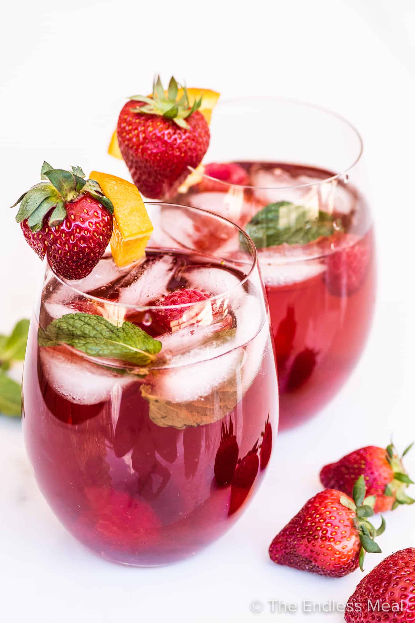rose sangria in glasses garnished with strawberries and oranges