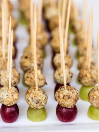 rows of blue cheese and grape appetizer on toothpicks on a plate.
