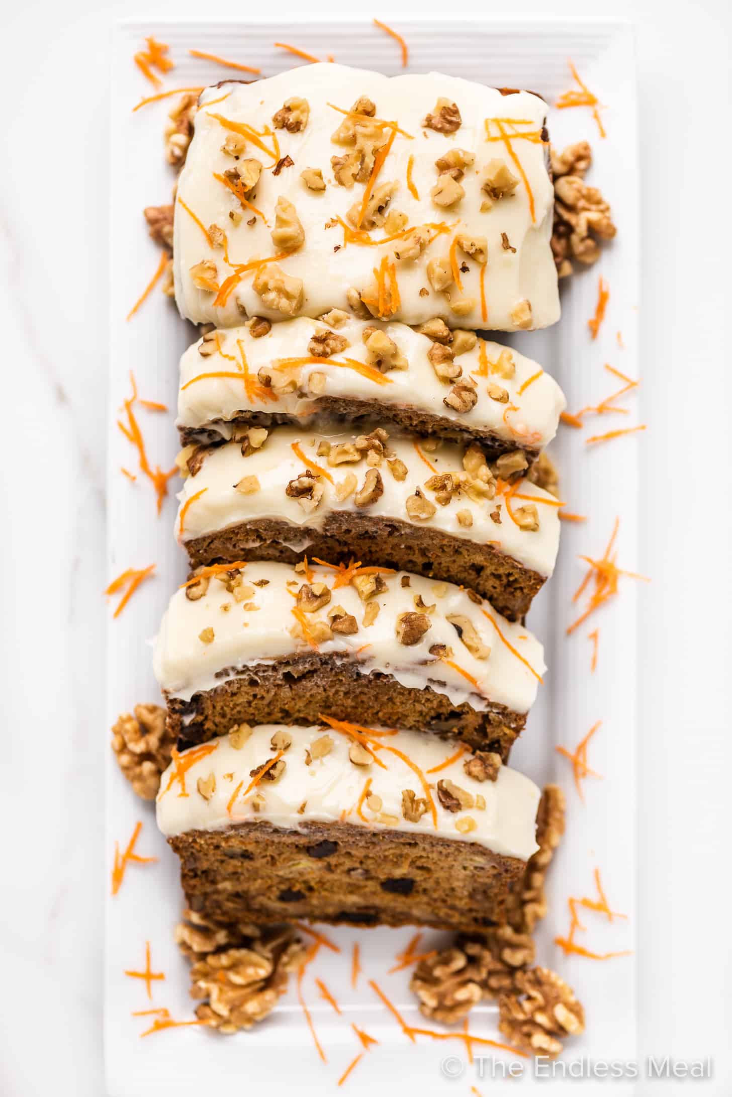 looking down on slices of carrot cake banana bread with cream cheese frosting