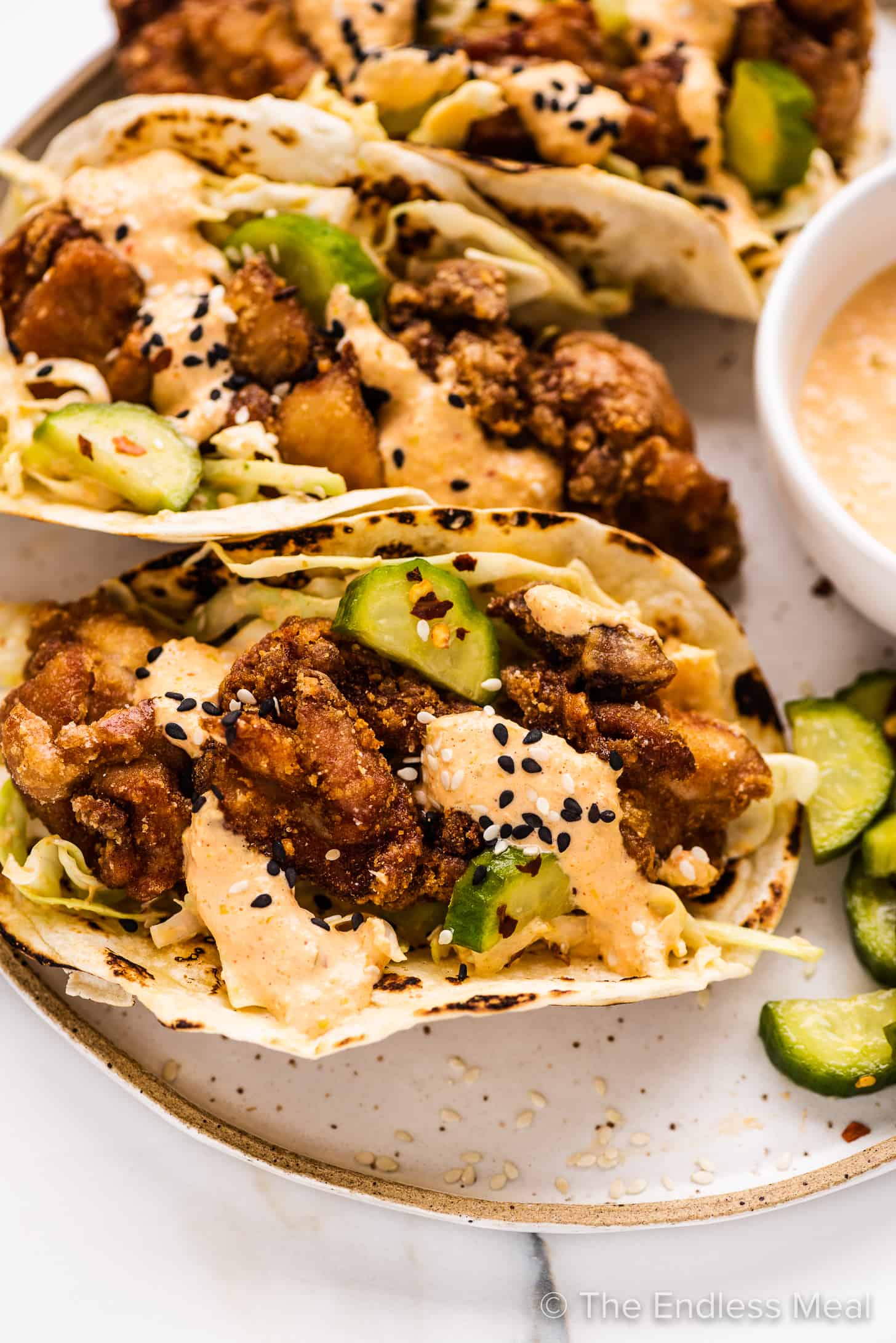 a close up of karaage chicken tacos on a plate.