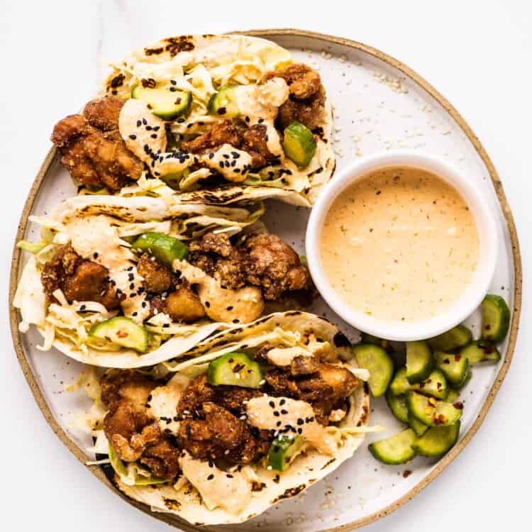 a plate of three chicken karaage tacos with a side of kimchi mayo