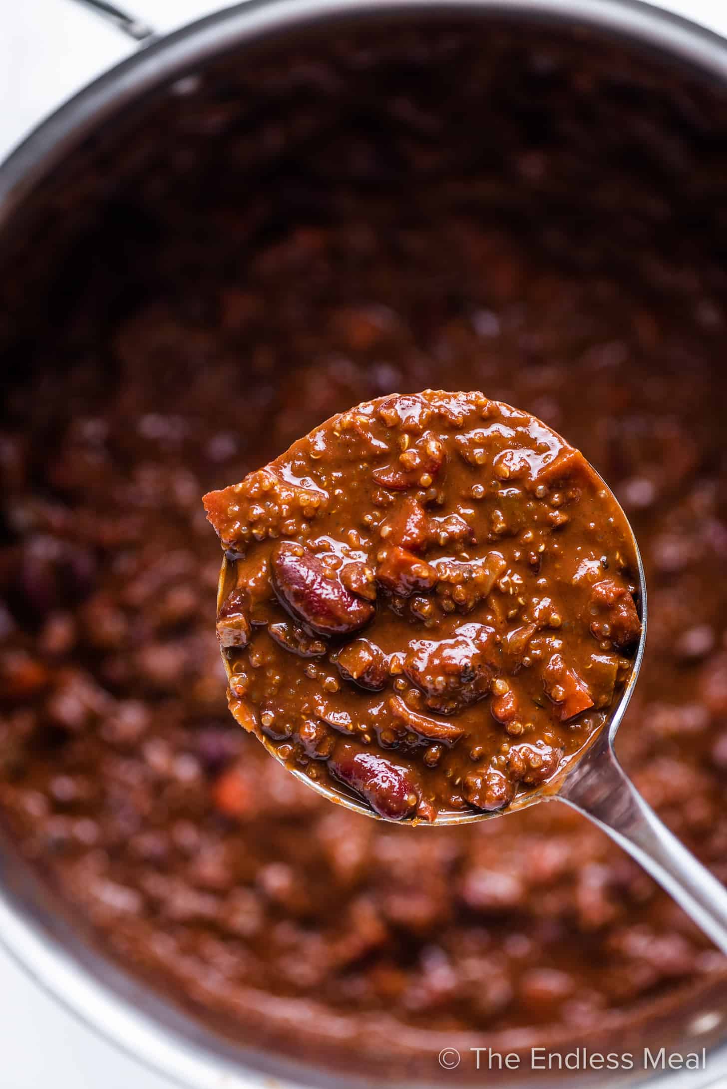 a ladle scooping up chocolate quinoa chili from a pot