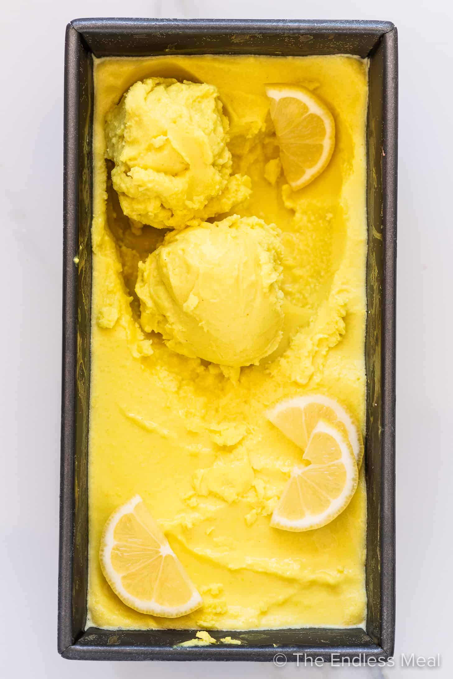 coconut cream lemon ice cream in a container with lemon slices