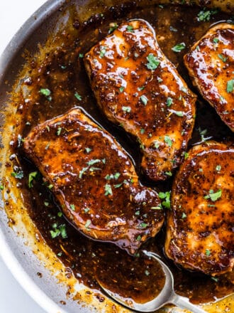 a pan of honey mustard pork chops with a spoon