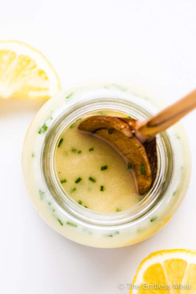 Lemon Salad Dressing in a jar with lemons on the side