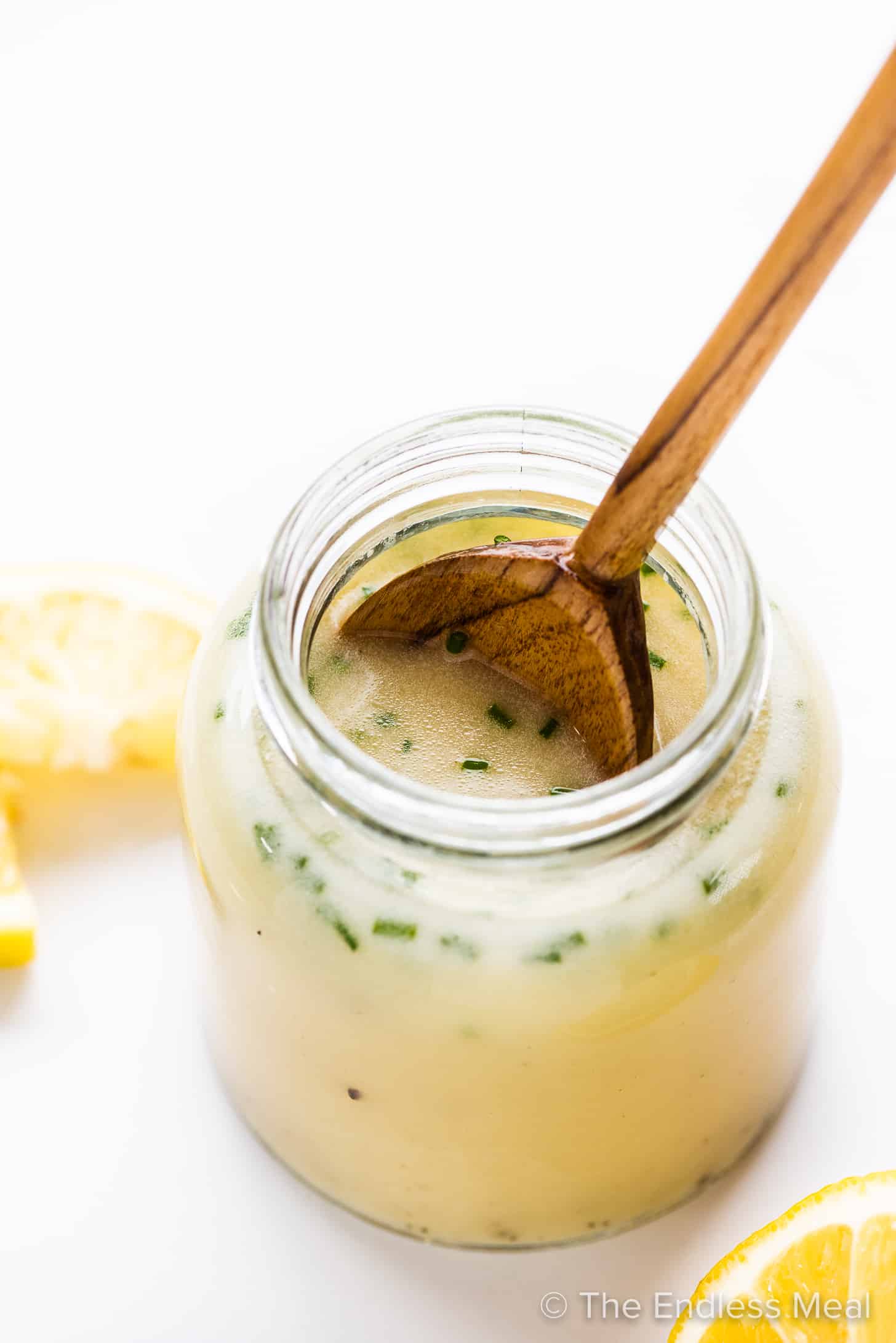 Lemon Salad Dressing in a jar with a spoon