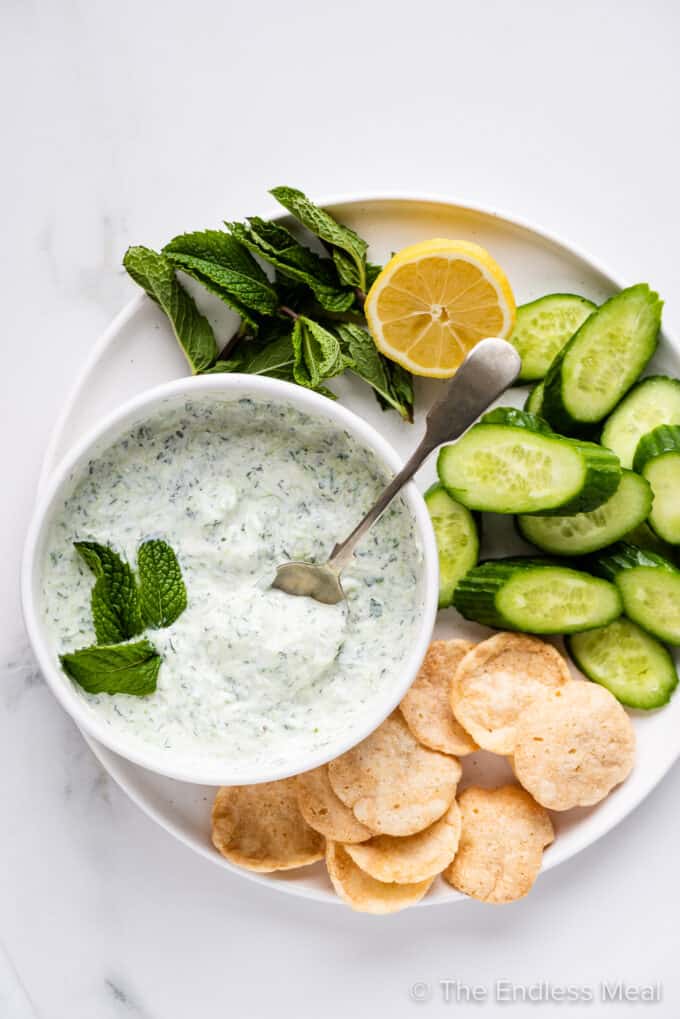 Mint Tzatziki in a white bowl with veggies on the side