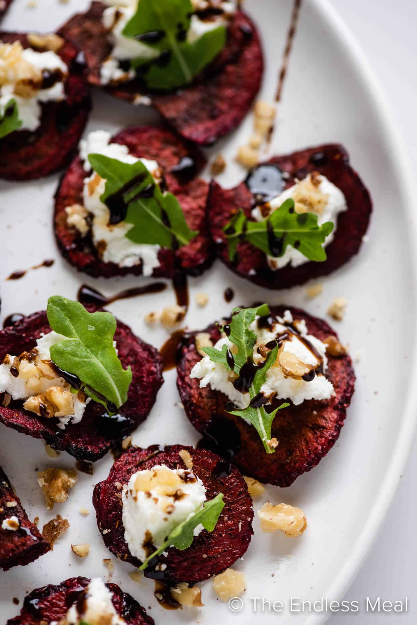 a close up of beet chips topped with goat cheese
