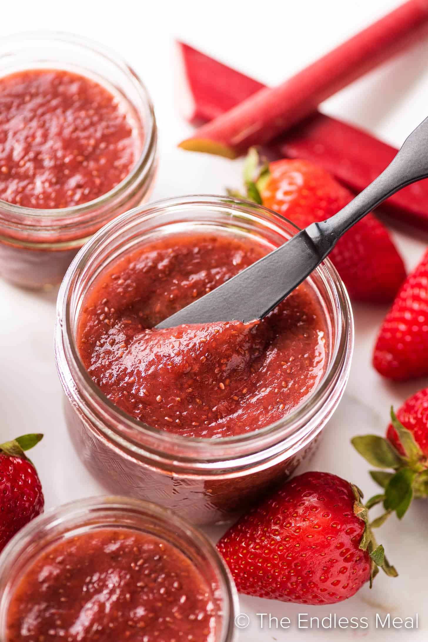 a knife scooping some chia jam out of a jar