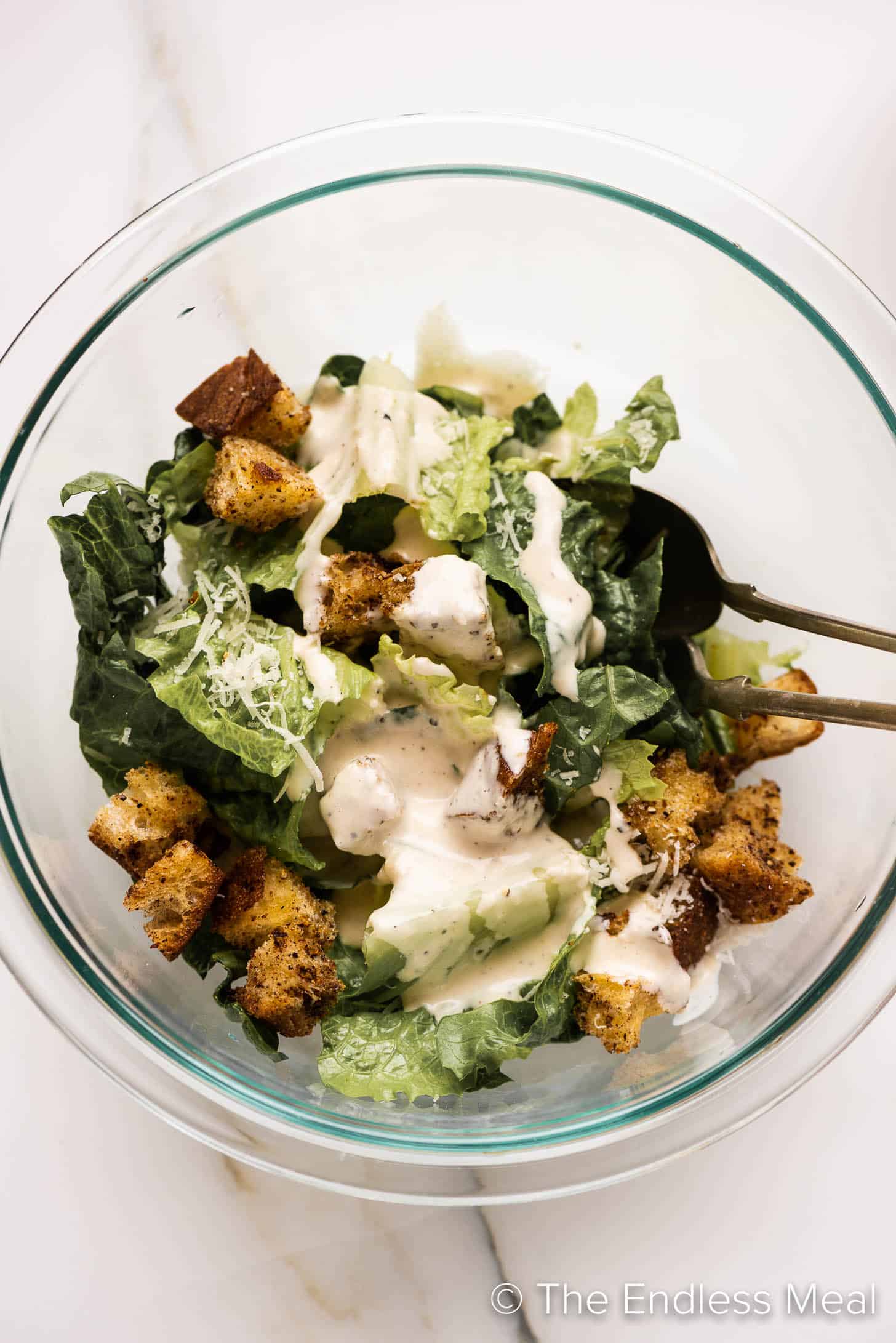 caesar salad in a bowl with our Easy Caesar Salad Dressing poured over the top.