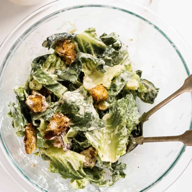 a bowl of caesar salad with a jar of our Easy Caesar Salad Dressing beside it.