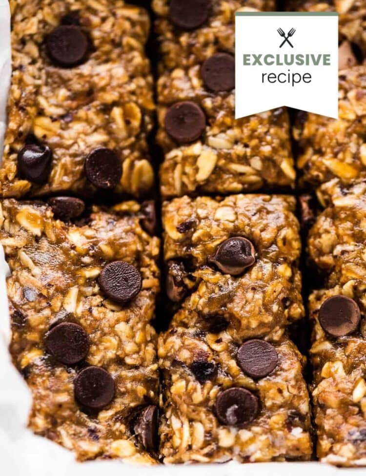 Close-up of homemade granola bars with oats and chocolate chips, cut into squares and arranged in a lined baking dish, perfect for pairing with a refreshing glass of blackberry lemonade.
