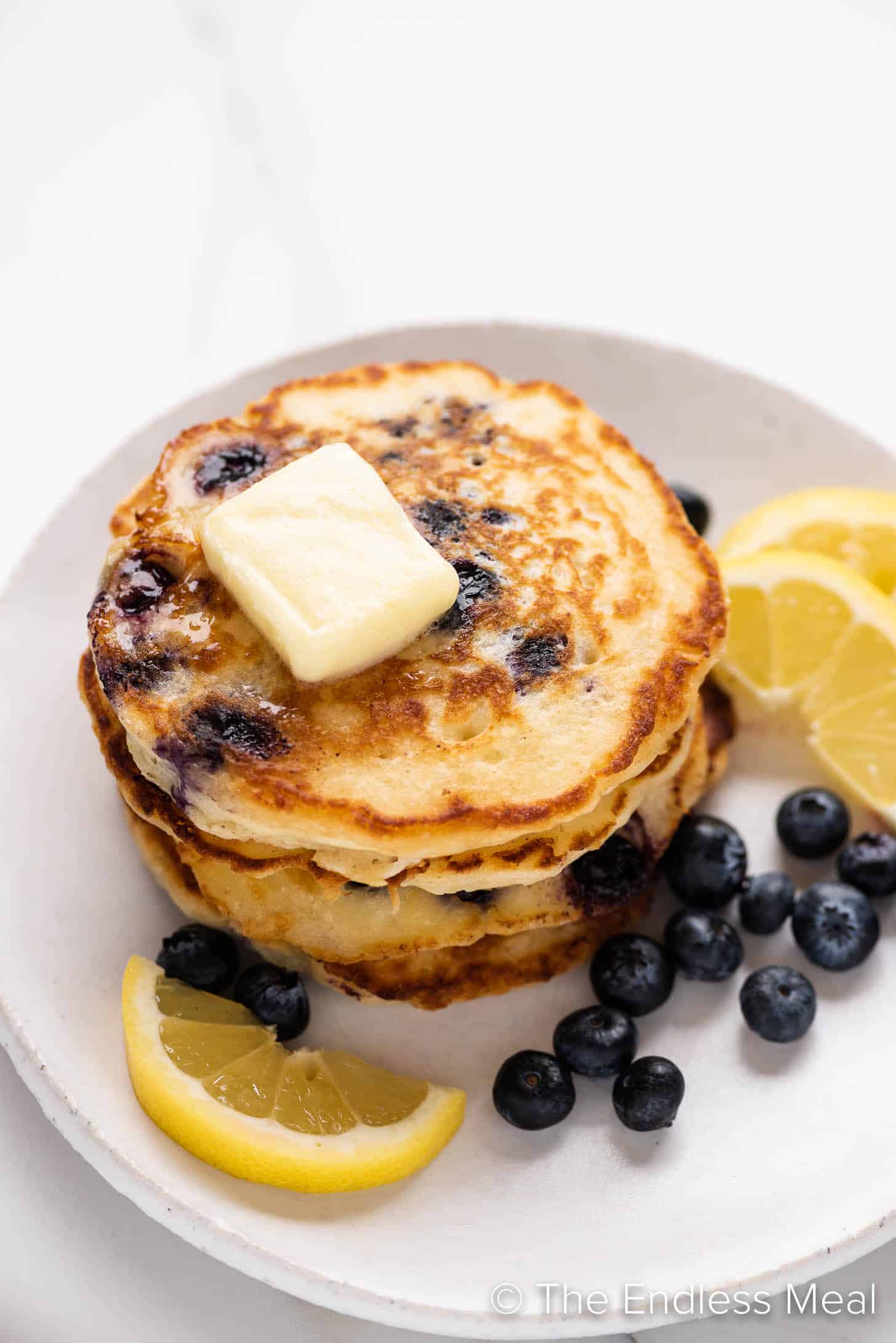 a stack of Lemon Blueberry Pancakes on a white plate