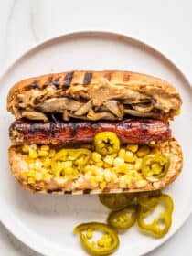 a Mexican Hot Dog on a plate with pickled jalapenos