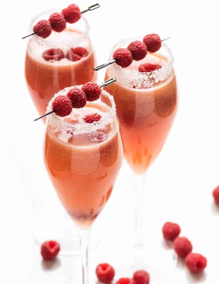 three Raspberry Mimosas in flute glasses